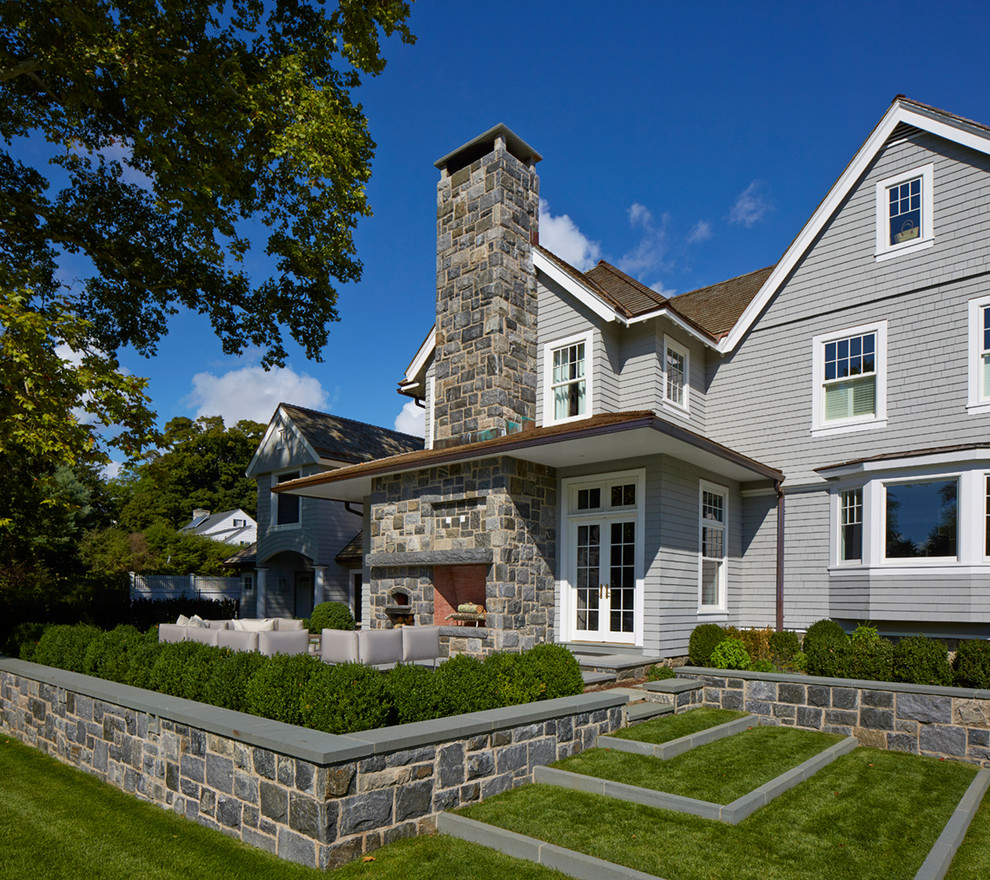 Inspiration pour une terrasse arrière traditionnelle de taille moyenne avec un foyer extérieur, une dalle de béton et une extension de toiture.