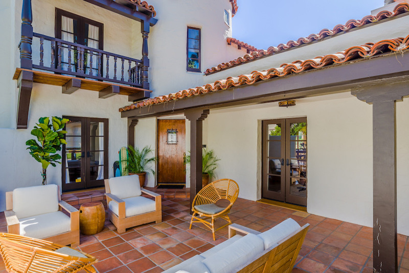 This is an example of a medium sized mediterranean side patio in Los Angeles with tiled flooring and a roof extension.