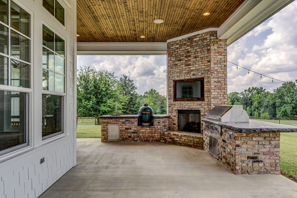 Immagine di un grande patio o portico country dietro casa con lastre di cemento e un tetto a sbalzo