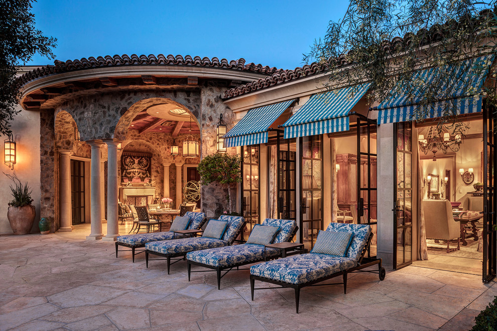 Immagine di un patio o portico mediterraneo di medie dimensioni e dietro casa con pavimentazioni in pietra naturale e nessuna copertura
