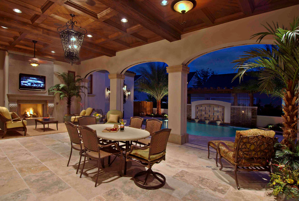 Inspiration for a large mediterranean backyard tile patio remodel in Orlando with a fire pit and a roof extension