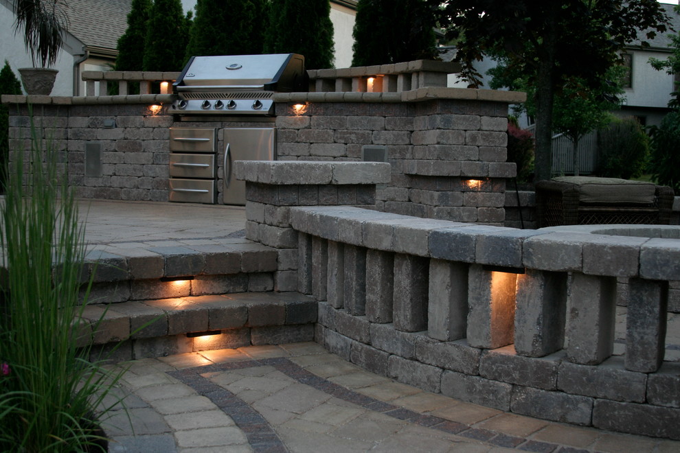 Example of a large backyard stone patio kitchen design in Columbus