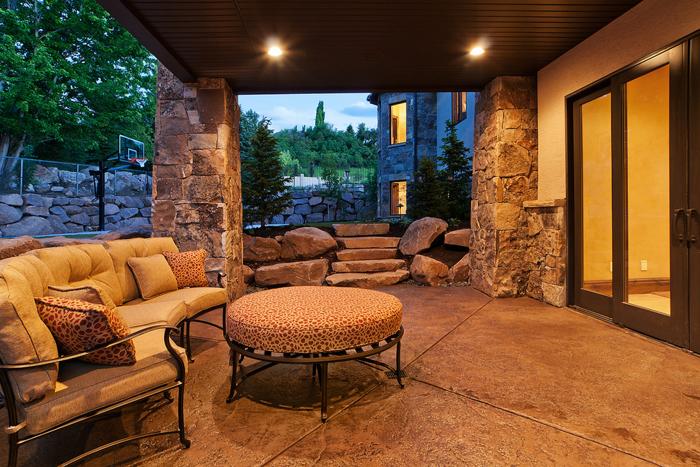 На фото: двор среднего размера на заднем дворе в стиле рустика с покрытием из бетонных плит и навесом