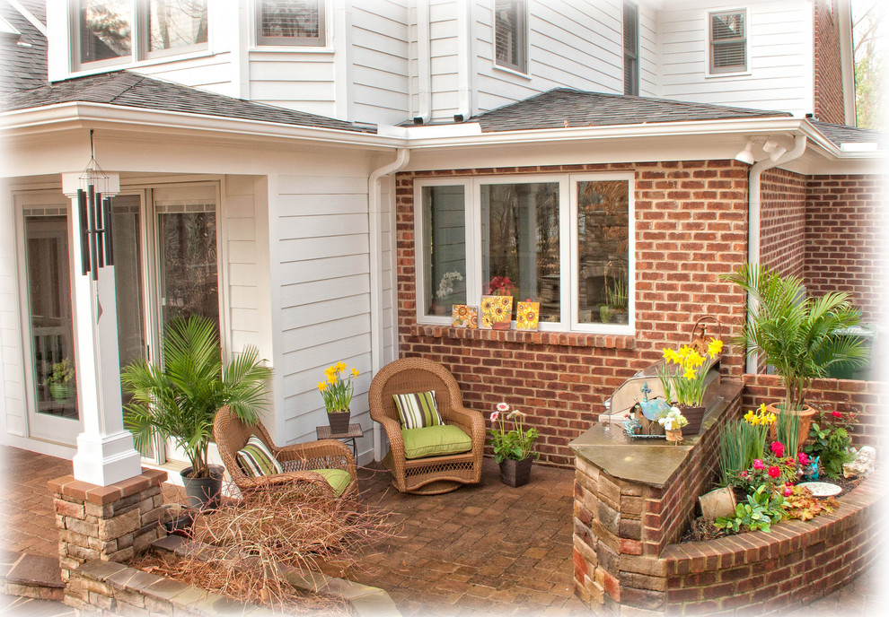 Medium sized classic back patio in Raleigh with a fire feature, concrete paving and a roof extension.