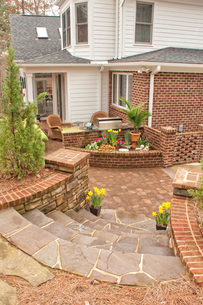 Patio - mid-sized traditional backyard concrete paver patio idea in Raleigh with a fire pit and a roof extension
