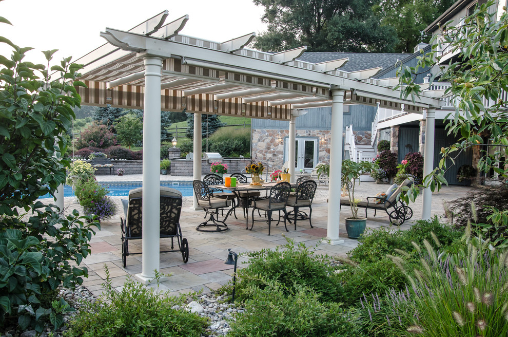 Immagine di un patio o portico classico dietro casa con una pergola