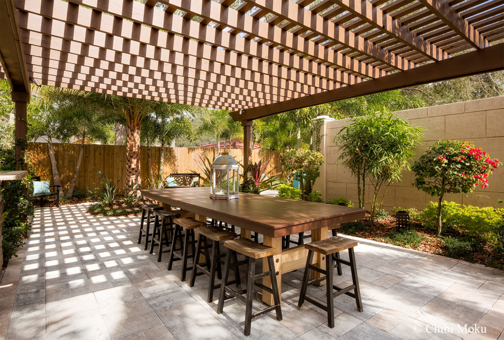 Example of a large classic courtyard concrete paver patio design in Tampa with a pergola