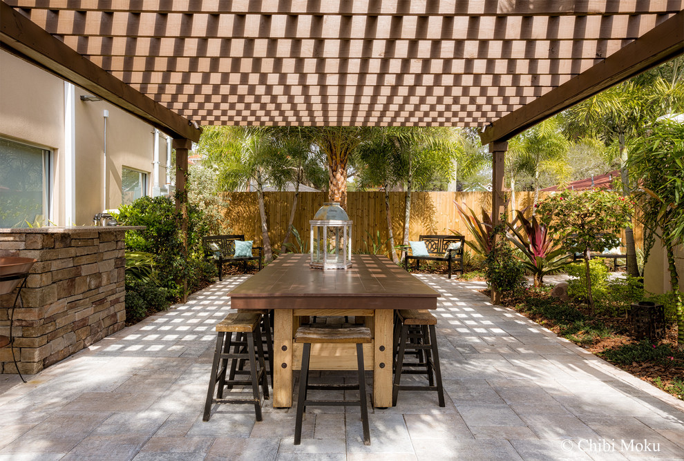 Patio - large traditional courtyard concrete paver patio idea in Tampa with a pergola