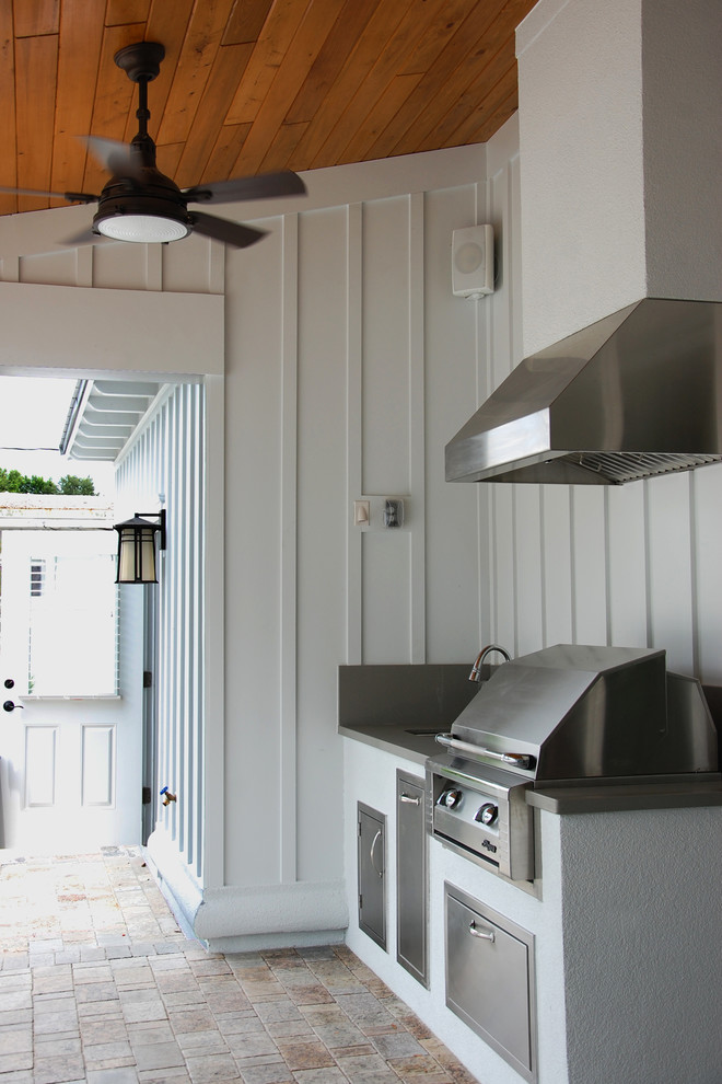 Photo of a medium sized farmhouse back patio in Orlando with an outdoor kitchen and a roof extension.