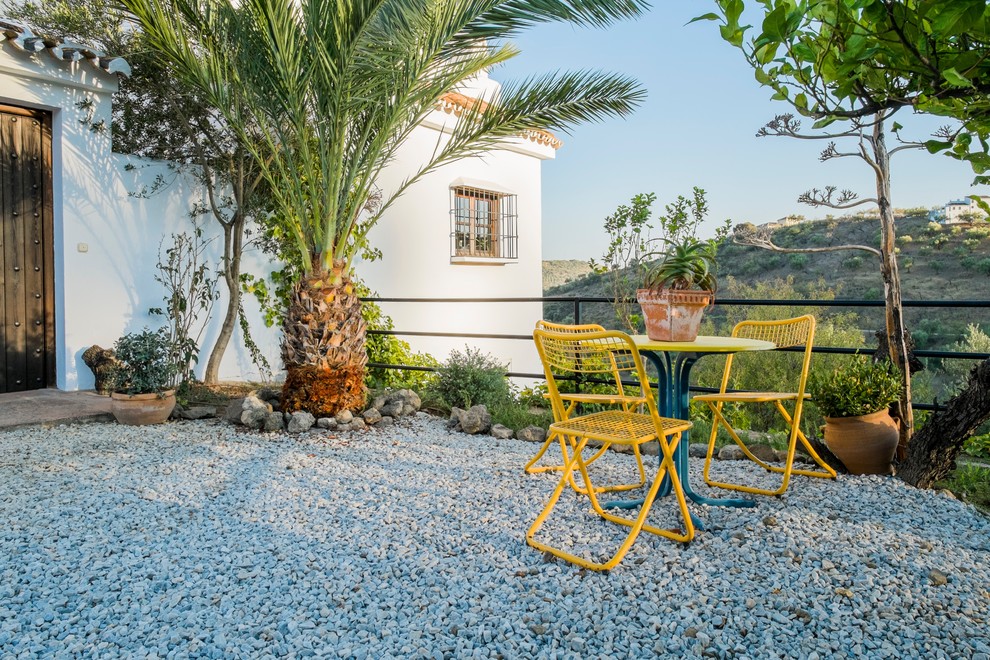 Cette photo montre une terrasse avec des plantes en pots avant méditerranéenne de taille moyenne avec du gravier et aucune couverture.