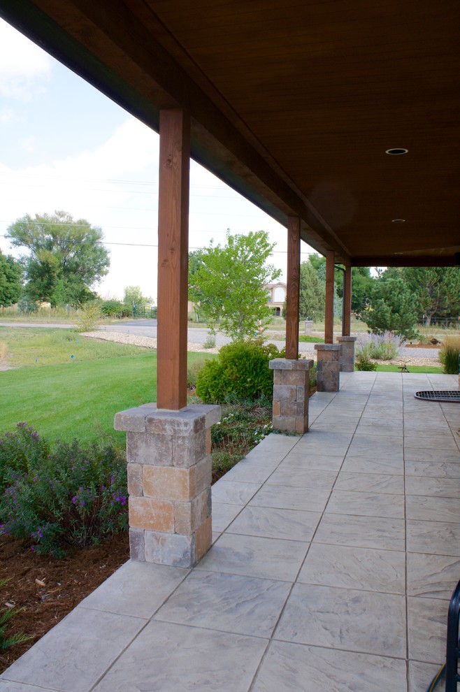 Immagine di un patio o portico dietro casa con pavimentazioni in cemento e una pergola