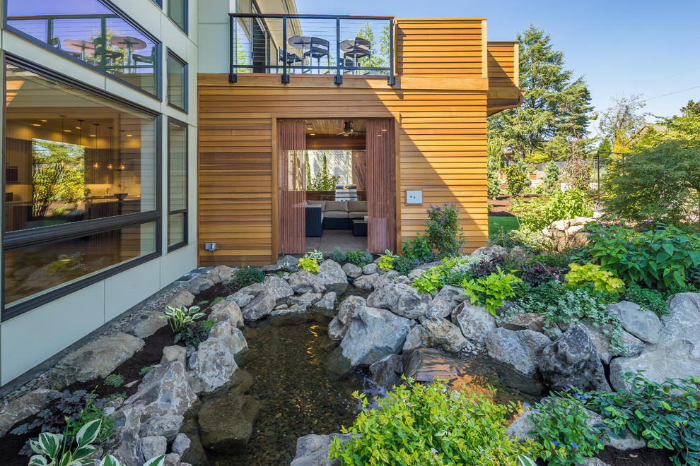 Inspiration pour une terrasse arrière design avec un foyer extérieur, une dalle de béton et une extension de toiture.