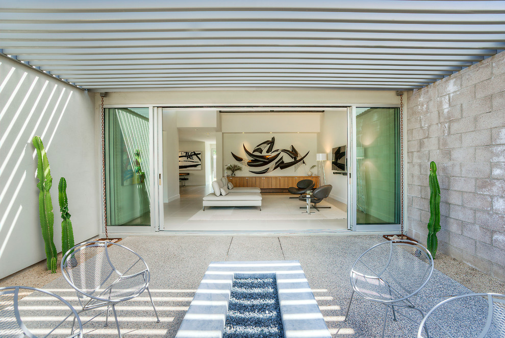 Imagen de patio moderno de tamaño medio en patio trasero con pérgola y granito descompuesto