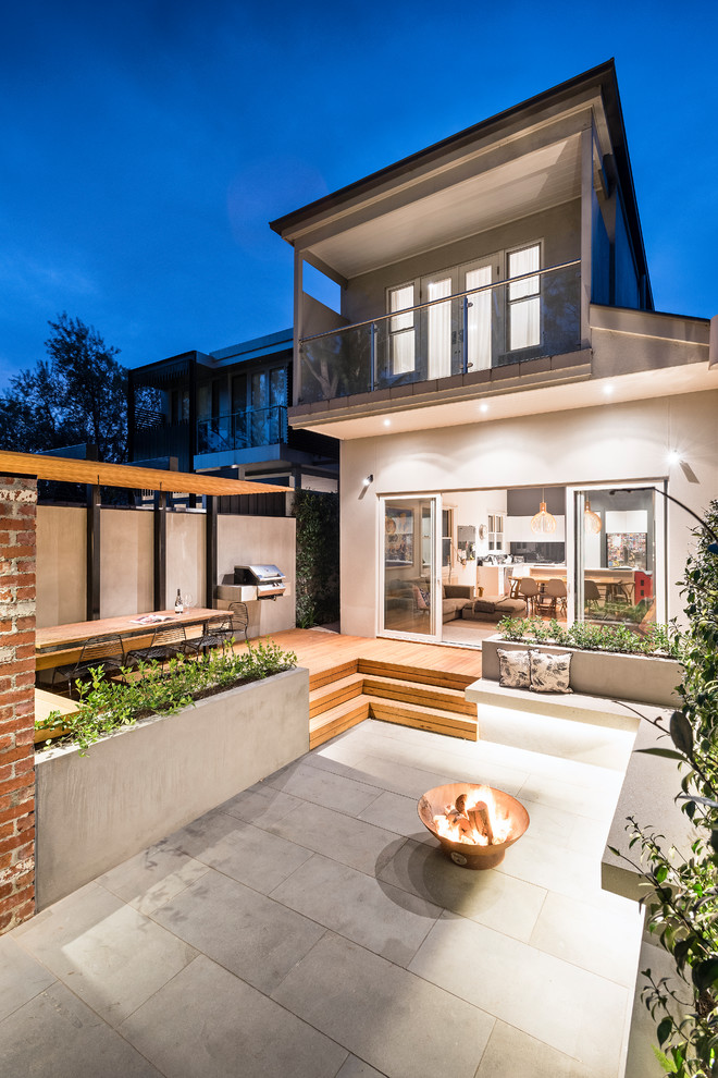 Unbedeckter Moderner Patio hinter dem Haus mit Feuerstelle und Betonboden in Melbourne