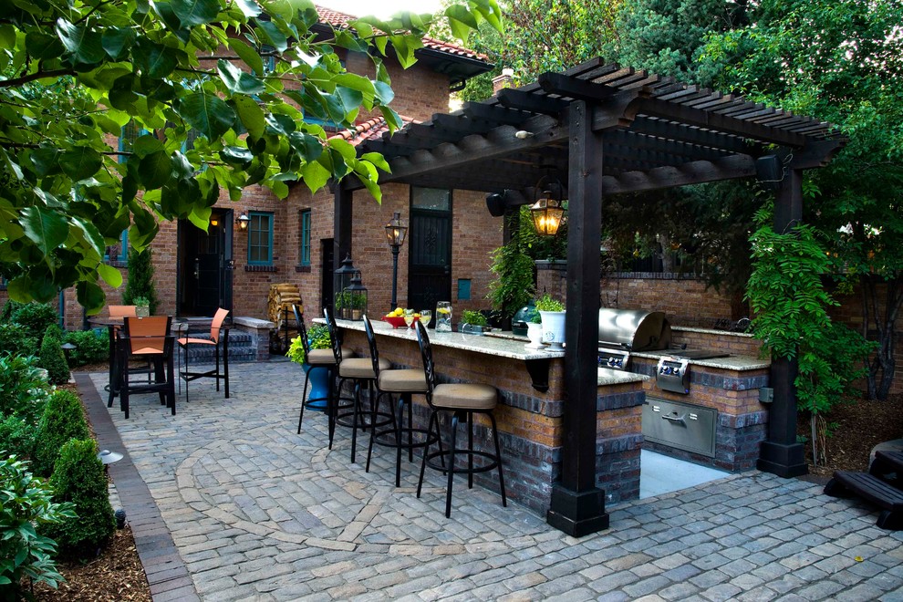 Foto di un patio o portico mediterraneo di medie dimensioni e dietro casa con pavimentazioni in mattoni e una pergola
