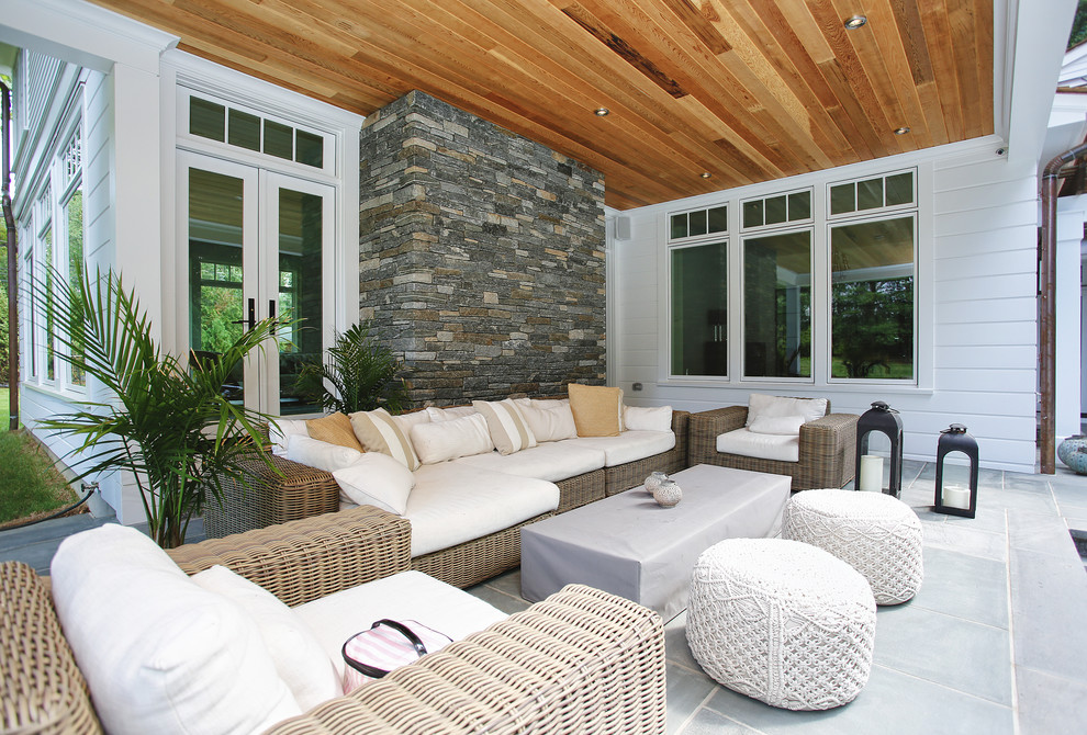 Huge transitional backyard stone patio photo in New York with a fire pit and a roof extension