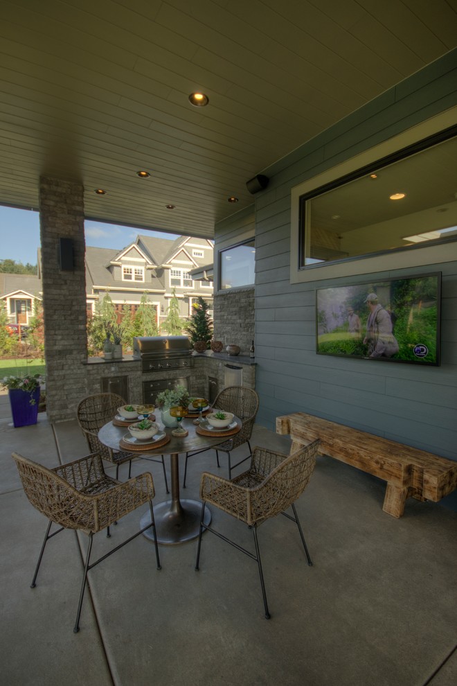 Exemple d'une très grande terrasse arrière tendance avec une cuisine d'été, une dalle de béton et une extension de toiture.