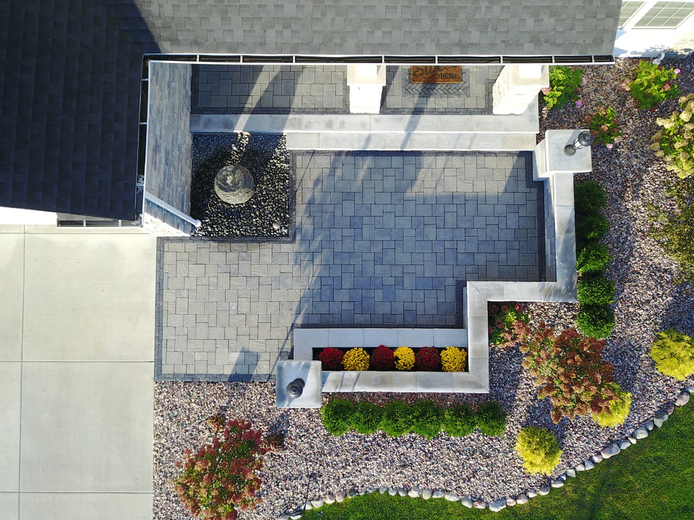 Immagine di un patio o portico minimalista di medie dimensioni e davanti casa con pavimentazioni in mattoni