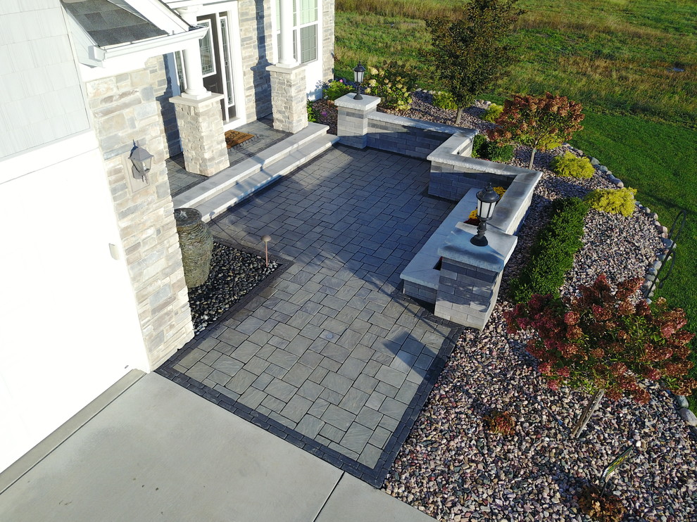 Cette image montre une terrasse avant minimaliste de taille moyenne avec des pavés en brique.
