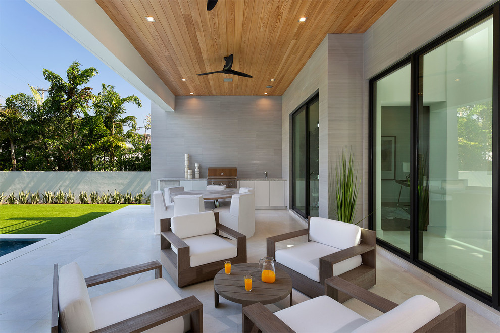 Überdachter, Großer Moderner Patio hinter dem Haus mit Outdoor-Küche und Stempelbeton in Miami