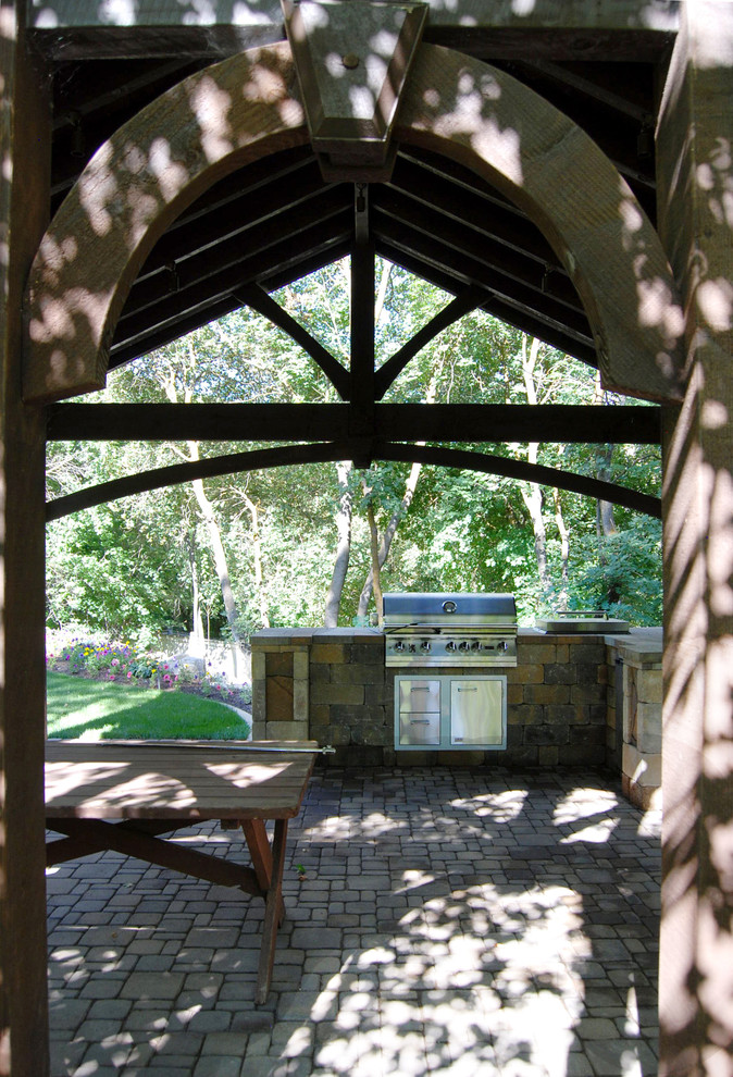 На фото: пергола во дворе частного дома в стиле рустика с летней кухней