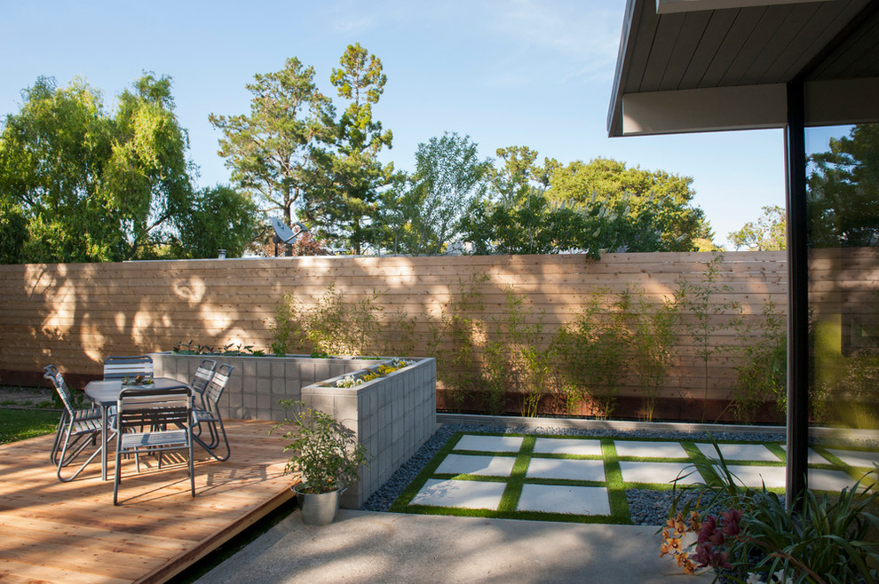 На фото: двор среднего размера на заднем дворе в стиле модернизм с покрытием из декоративного бетона и навесом с