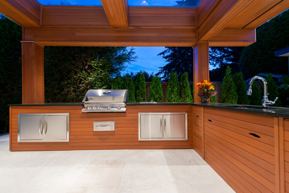 Aménagement d'une grande terrasse arrière contemporaine avec une cuisine d'été, du carrelage et une extension de toiture.