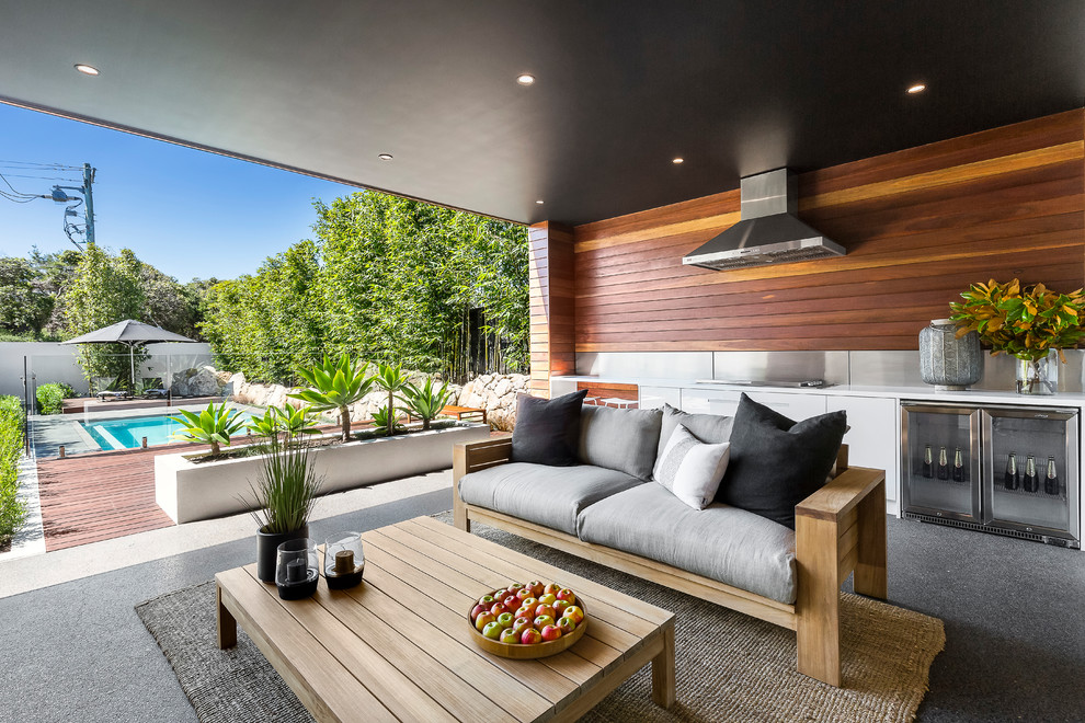 Inspiration pour une terrasse arrière design avec une cuisine d'été et une extension de toiture.