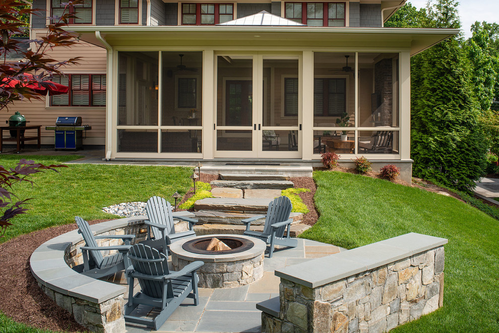 Modelo de patio clásico renovado de tamaño medio en patio trasero y anexo de casas con chimenea y adoquines de piedra natural