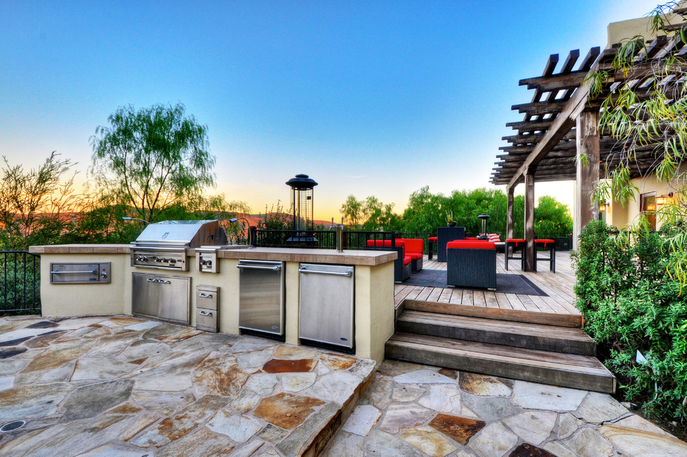 Example of a huge transitional backyard patio kitchen design in Los Angeles with a gazebo