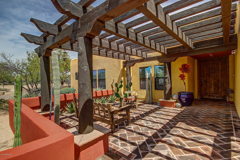 Esempio di un patio o portico stile americano con pavimentazioni in mattoni e una pergola