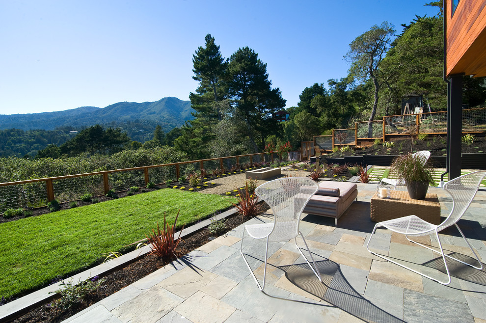 Cette photo montre une terrasse tendance avec des pavés en pierre naturelle.
