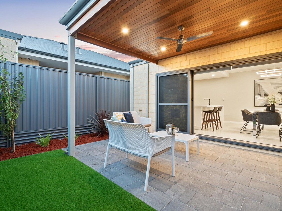 Small modern back patio in Perth with brick paving and a roof extension.