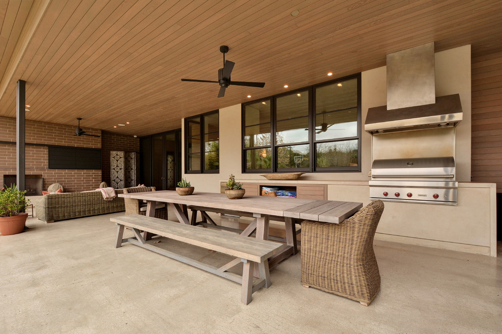 Foto di un patio o portico design con lastre di cemento e un tetto a sbalzo