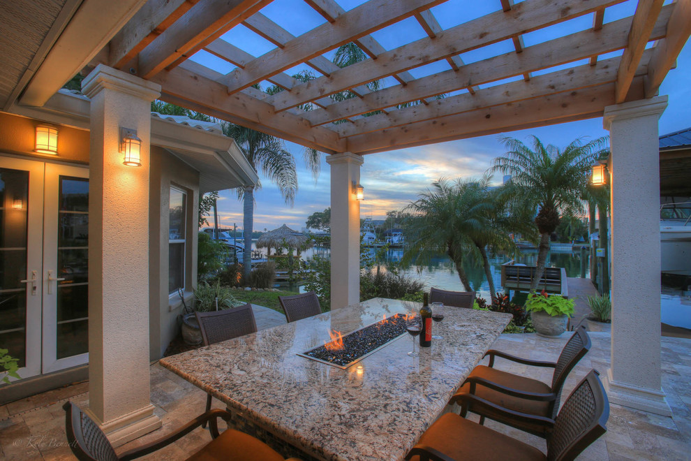 Inspiration for a mid-sized timeless backyard stone patio remodel in Tampa with a fire pit and a pergola
