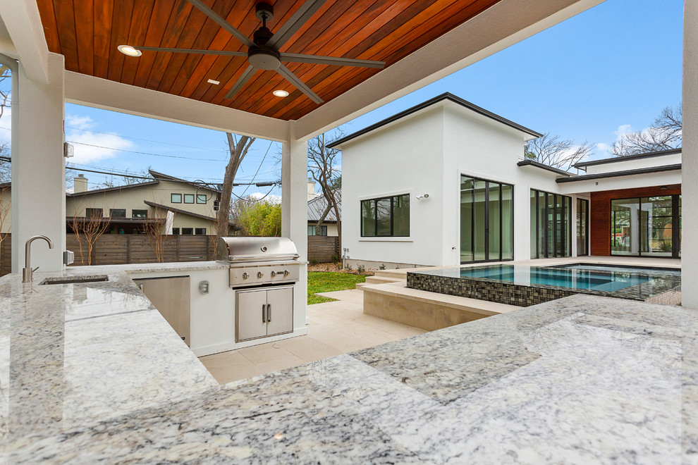 Großer Moderner Patio hinter dem Haus mit Outdoor-Küche, Natursteinplatten und Gazebo in Austin