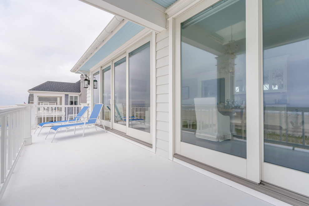 Inspiration pour une terrasse arrière marine de taille moyenne avec une dalle de béton et une extension de toiture.