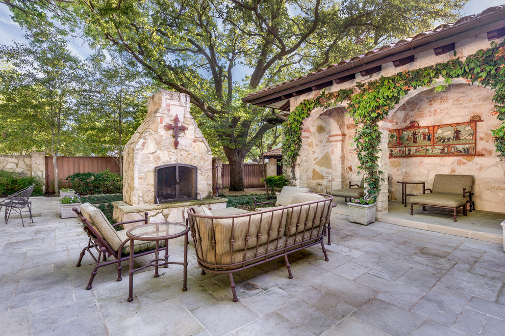 This is an example of a mediterranean patio in Dallas with no cover and a fireplace.
