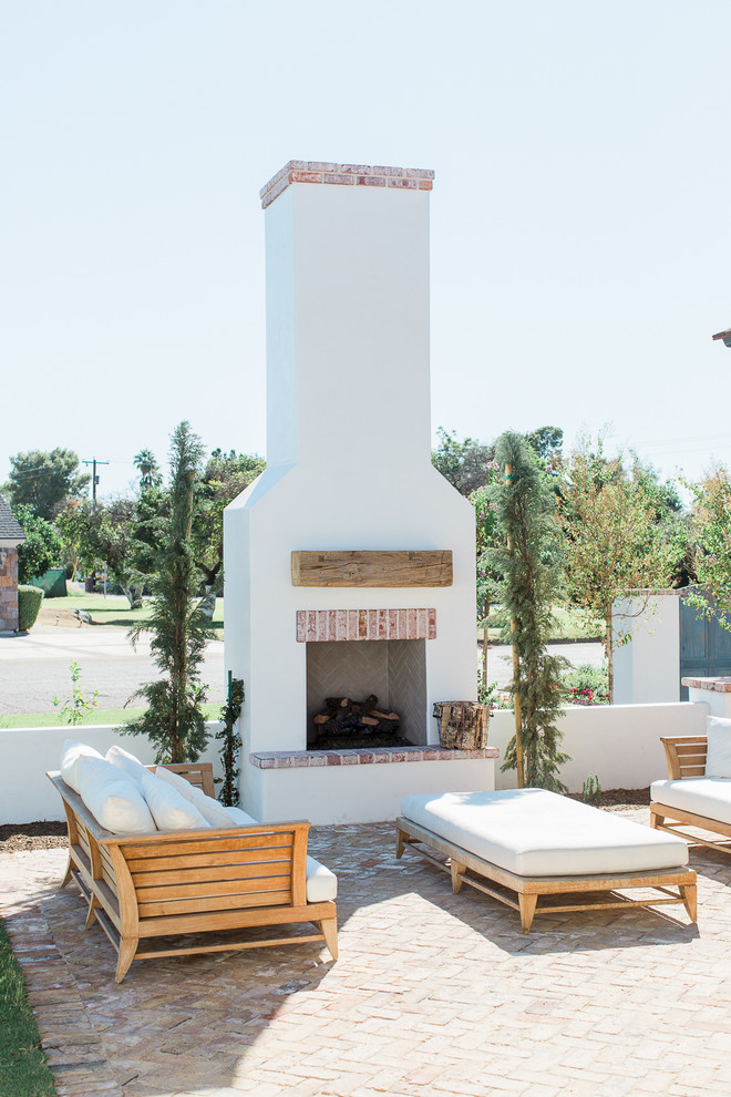 Mid-sized elegant courtyard brick patio photo in Phoenix with a fire pit