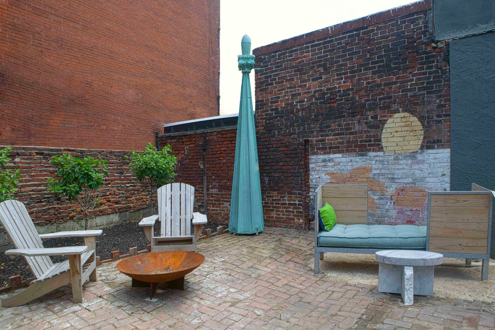 Foto de patio ecléctico sin cubierta en patio trasero con brasero y adoquines de ladrillo
