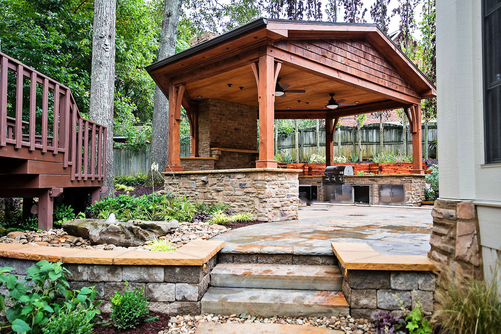 Diseño de patio clásico de tamaño medio en patio trasero con cocina exterior, adoquines de piedra natural y cenador