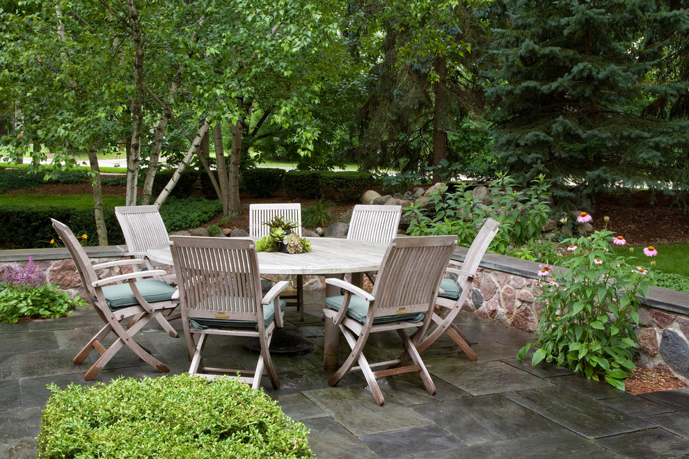 Idées déco pour une terrasse arrière classique de taille moyenne avec des pavés en pierre naturelle, un foyer extérieur et aucune couverture.