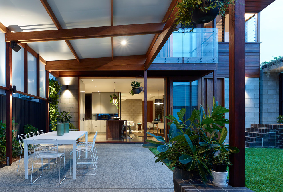 Immagine di un patio o portico design dietro casa con lastre di cemento e una pergola