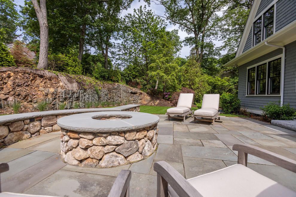 Стильный дизайн: огромный двор на заднем дворе в классическом стиле с местом для костра и покрытием из каменной брусчатки - последний тренд