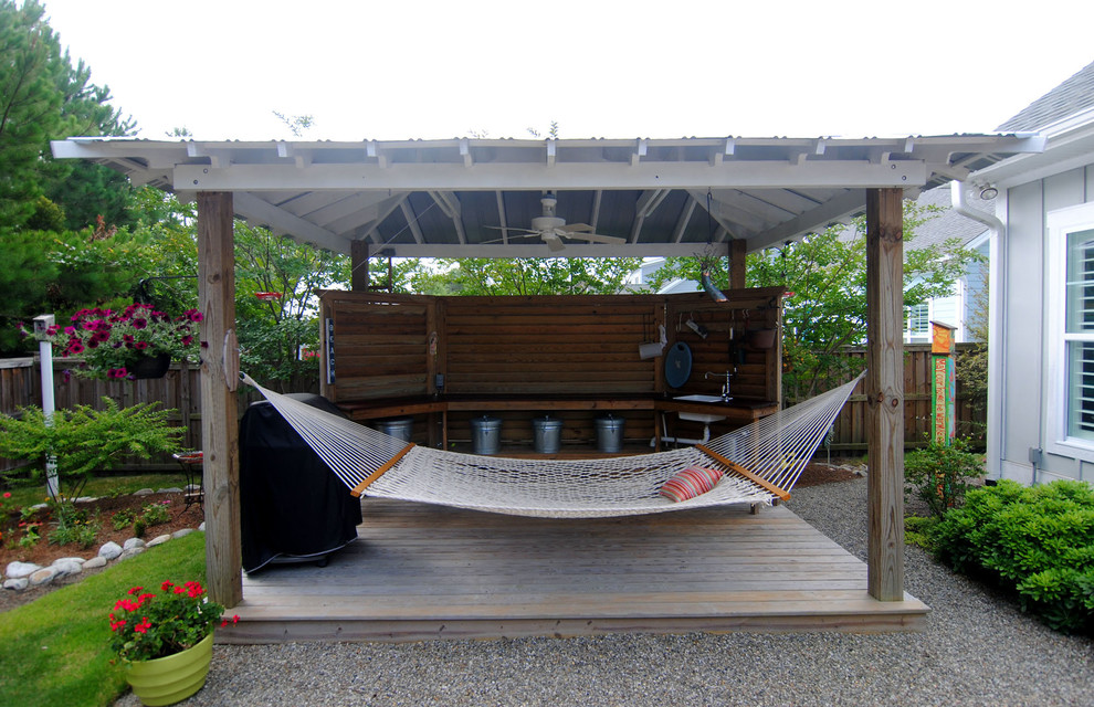 Idee per un grande patio o portico tropicale dietro casa con pedane e una pergola