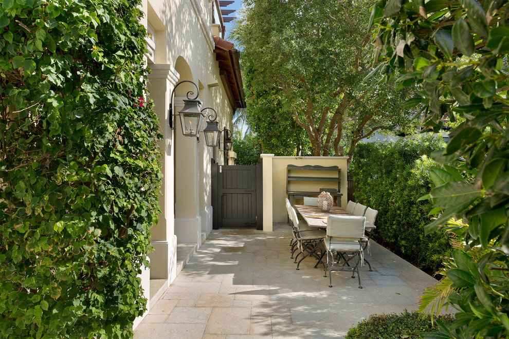 Patio - mid-sized mediterranean side yard stamped concrete patio idea in Miami with no cover