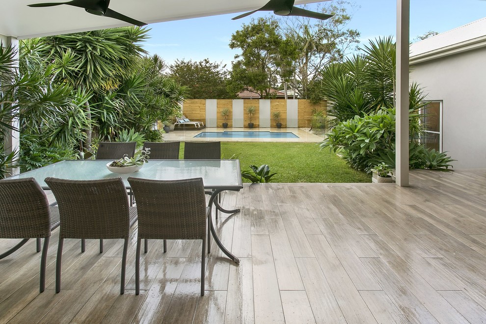 Design ideas for a modern back patio in Sydney with a roof extension.
