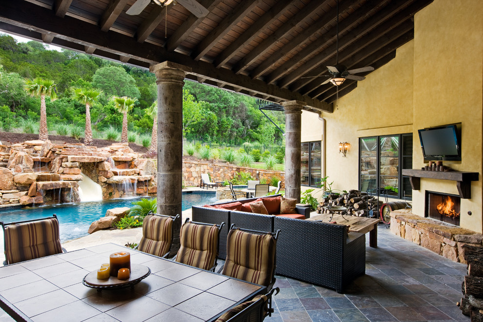 Diseño de patio mediterráneo grande en patio trasero y anexo de casas con fuente y adoquines de piedra natural