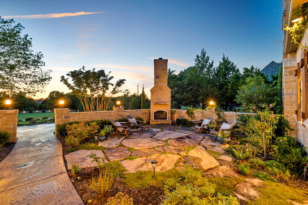 Classic patio in Dallas with natural stone paving, no cover and a fireplace.