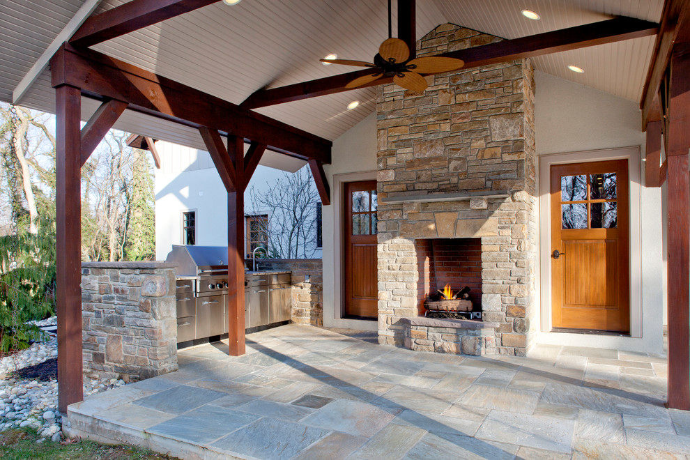 Design ideas for a traditional back patio in Philadelphia with an outdoor kitchen, natural stone paving and a roof extension.